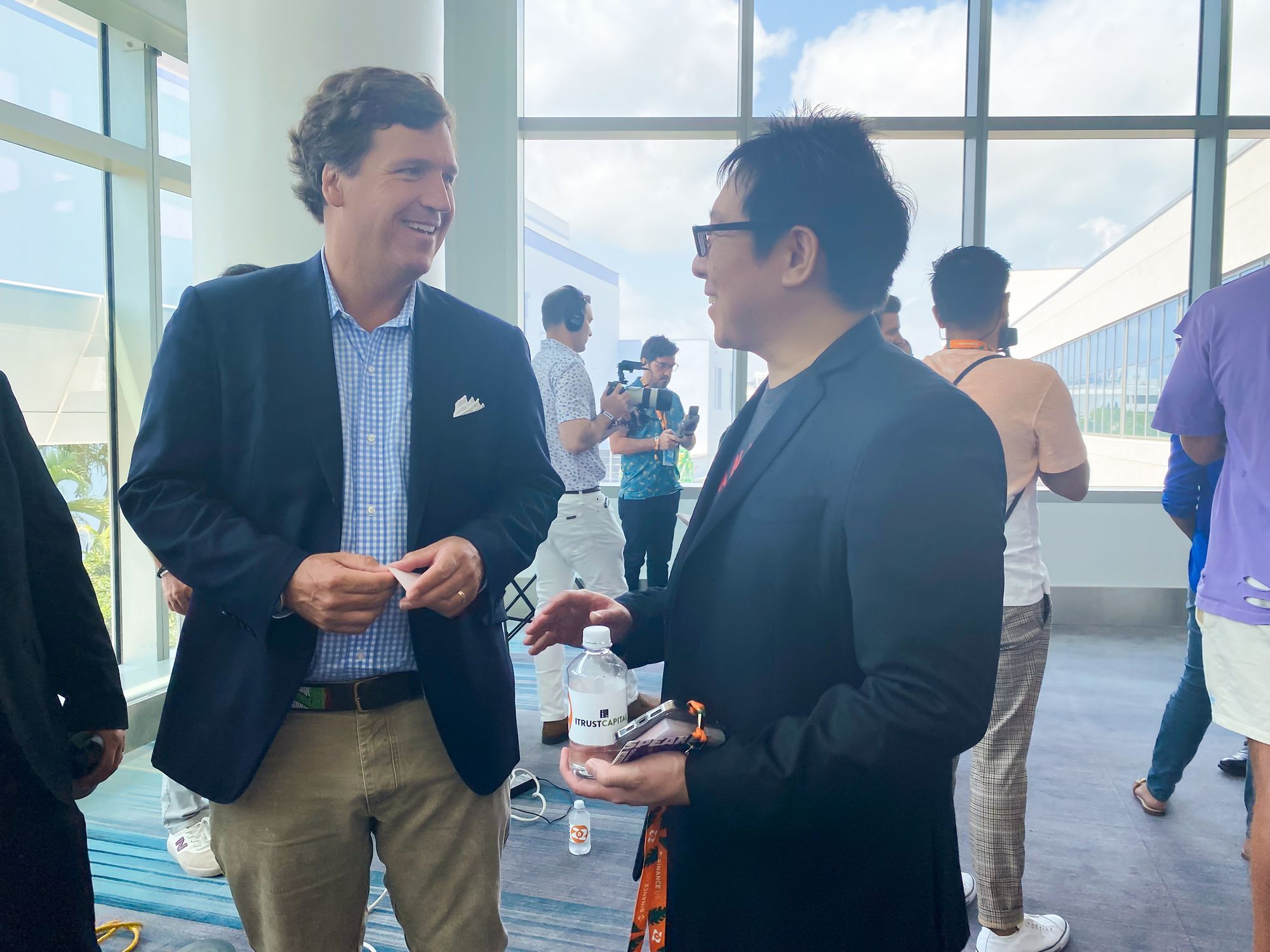 Samson Mow exchanging business cards with Tucker Carlson at Bitcoin 2022 in Miami