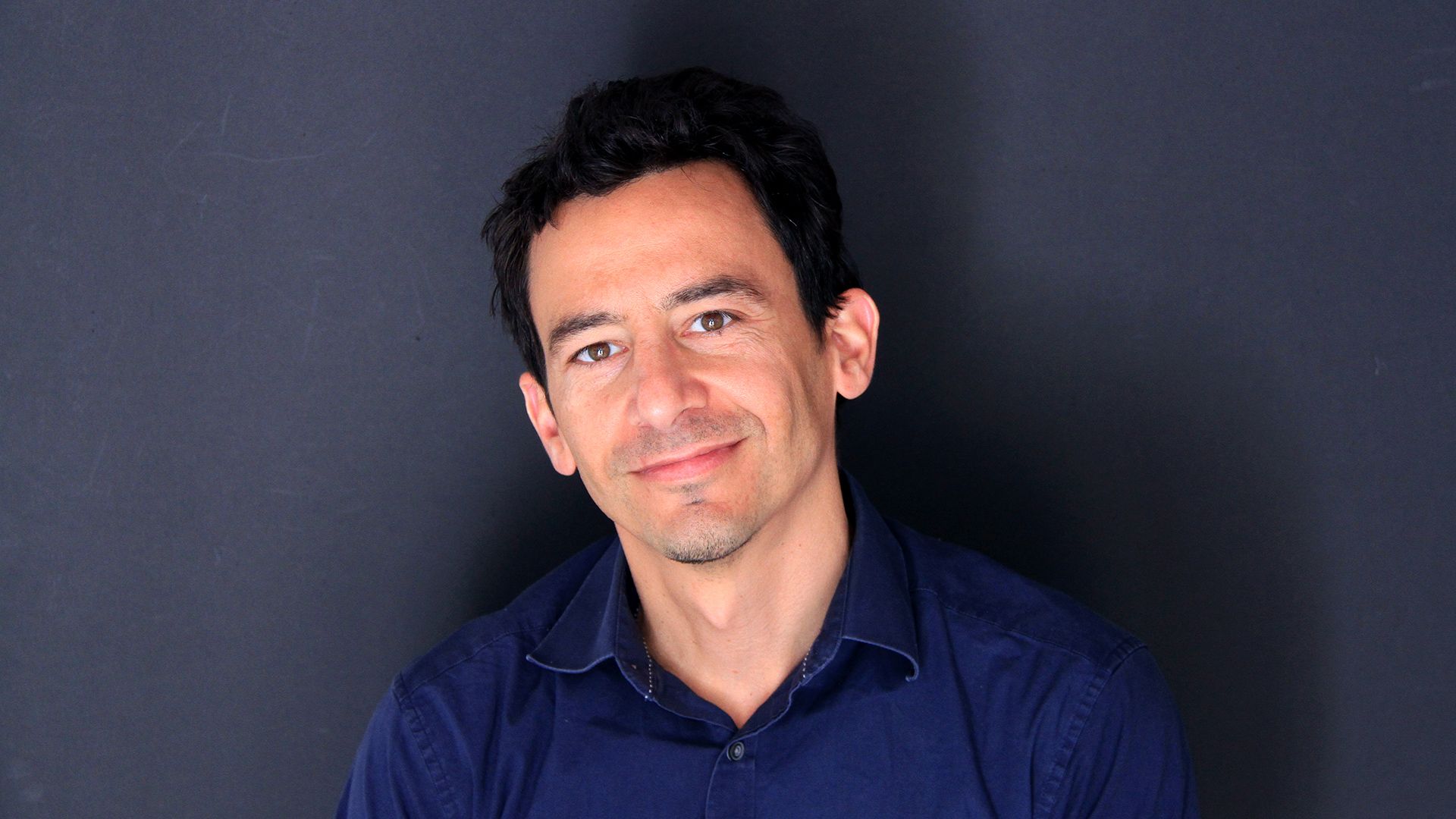 Headshot of industrial designer Stiven Kerestegian posing in front of dark background